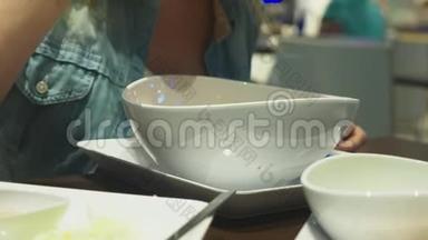 虾汤是泰国菜，味道酸辣.. 男人在餐馆的桌子上吃山药。 特写镜头。 概念